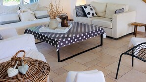 A modern living room with a sofa, a coffee table, and a staircase. - Sunny family home, 900m. from beach, equipped garden with a shower, WIFI HD, TV (Plurien)