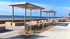 A beach walkway with wooden pergolas and concrete planters. - Classified 2** T2 + cabin apartment facing the sea - Miramar beach - private parking (La Londe-Les-Maures)