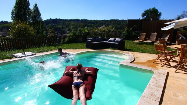 A swimming pool with a person lying on a red float.