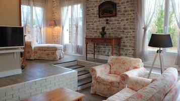 Televisie, een open haard, boeken en een kantoor