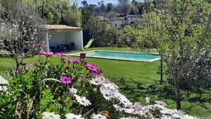A garden with a swimming pool, a covered seating area, and a hammock. - Country house with private pool, 20 minutes from the sea ideal for families (Saint Jeannet)