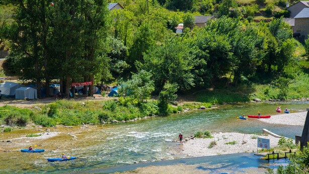 A river with kayaks, tents, and a sign indicating a canoe rental service. - Logement 4/6 pers. - Blajoux (Quézac)