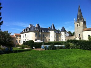 A large, historic building with multiple towers and a well-maintained garden. - Castle near Puy du Fou, in the heart of the Vendée Bocage (Sèvremont)