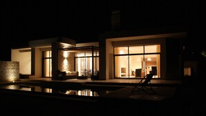 Uma casa moderna com piscina, grandes janelas e fachada de pedra.