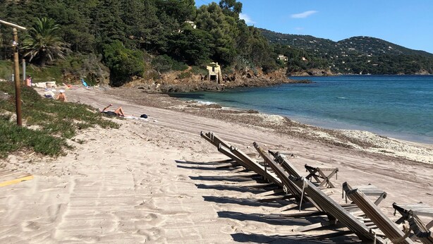 A beach with wooden loungers and a clear view of the sea. - Apartment, facing the sea, near the beach, 6 people, 2 bedrooms (Le Lavandou)