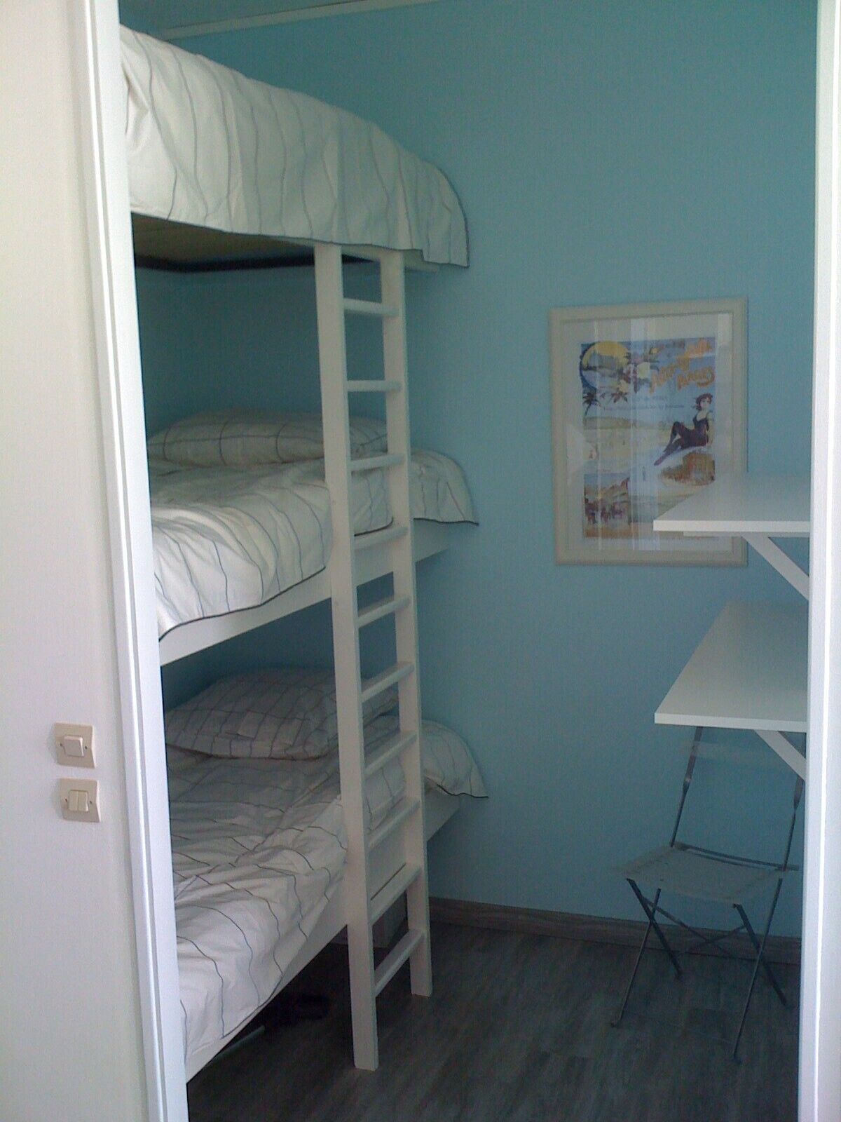 A bunk bed room with a framed picture on the wall.
