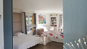 Une chambre à coucher avec un lit, une bibliothèque et une vue sur l’extérieur.