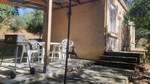 A covered outdoor area with a grill, plastic chairs, and a water tap. - Mini-villa 300m beach. (Calcatoggio)