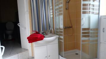 Une salle de bain avec une douche, un lavabo et des toilettes.