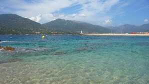 A coastal scene with clear turquoise water, a sandy beach, and a mountainous backdrop. - Resa 2025 open! SUPERB SEA VIEW mini villa heated pool Serra di Ferro (Serra-Di-Ferro)