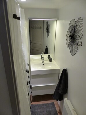 Tina con regadera, secadora de cabello, toallas, papel de baño 