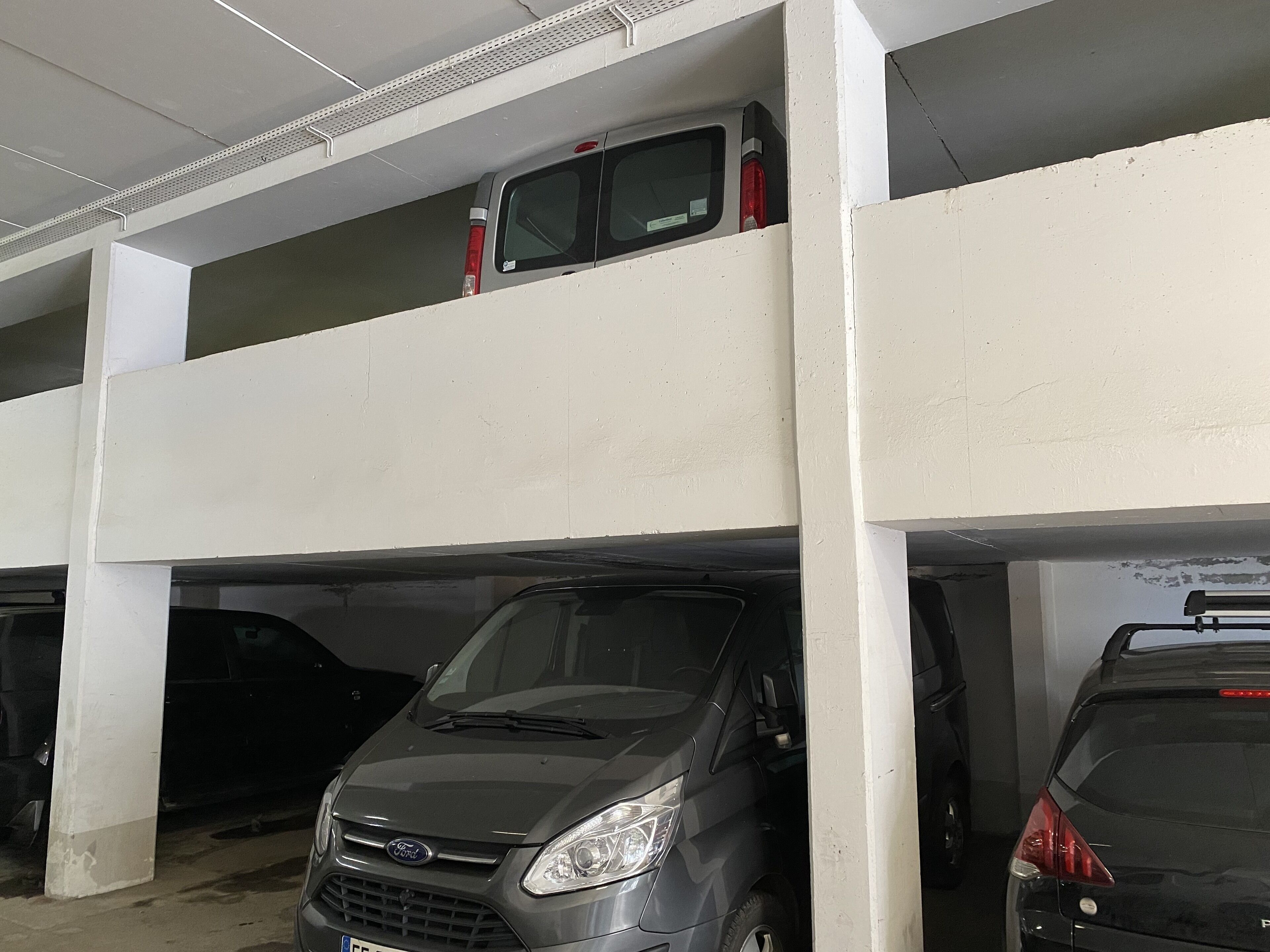 A multi-level parking garage with vehicles parked on both floors.