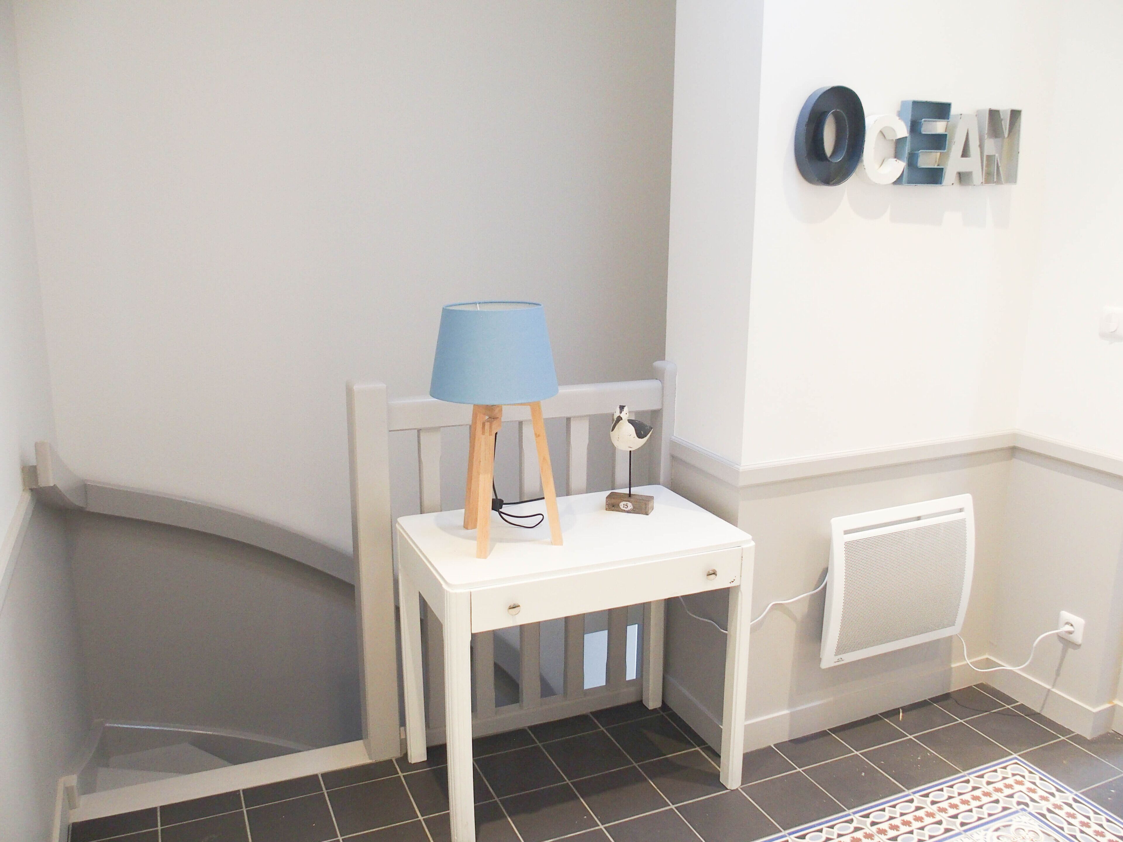 A white chair with a blue lampshade and a small wooden block.