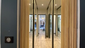 A hallway with wooden paneling and a light switch on the wall.