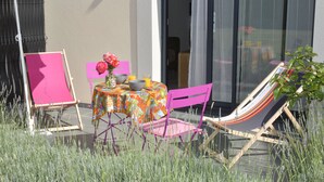 Un patio exterior con una mesa, sillas y una hamaca.