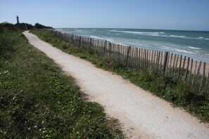 Stroll along the oceanfront path, lined with lush greenery and a historic lighthouse in the distance.