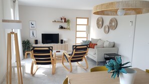 Relax in this stylish living room with a flat-screen TV, comfortable sofa, and dining area.