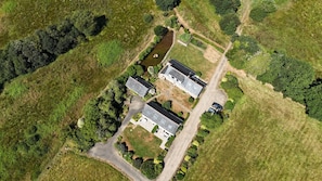 An aerial view of a property with two main buildings, a driveway, and surrounding greenery. - The stable, quiet house in the countryside (Quéménéven)