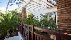 Un bâtiment moderne doté d’une terrasse en bois et d’une pergola blanche.