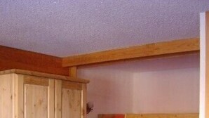 Ein Zimmer mit einem Etagenbett, einem Holzschrank und einer Leiter.