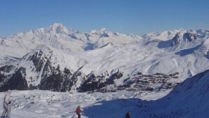 Eine verschneite Berglandschaft mit blauem Himmel.