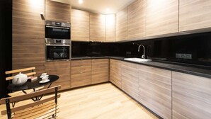 Eine moderne Küche mit Holzschränken, schwarzen Arbeitsplatten und Edelstahlgeräten.