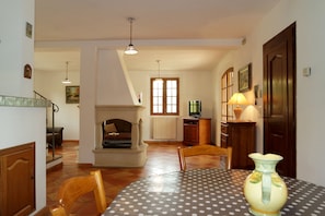Enjoy a romantic dinner for two in this cozy dining area with a fireplace and staircase leading to an upper level.