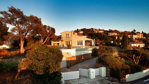 A two-story house with a swimming pool, surrounded by lush greenery and a stone wall. - Villa with an exceptional view of the sea and the bay of Agay (Saint-Raphaël)
