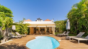 A pool area with lounge chairs and a covered patio.