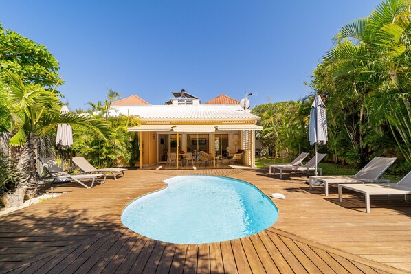 A pool area with lounge chairs and a covered patio. - Beautiful villa with a pool, just a one-minute walk from the lagoon—no roads to cross. (Saline Les Bains)