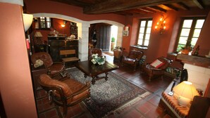 A cozy living room with leather furniture, a fireplace, and a rustic ceiling. - Charming cottages 3 stars, 20m pool, WIFI, dream setting, river (Le Tech)