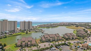 A resort with multiple buildings, a marina, and a view of the ocean.