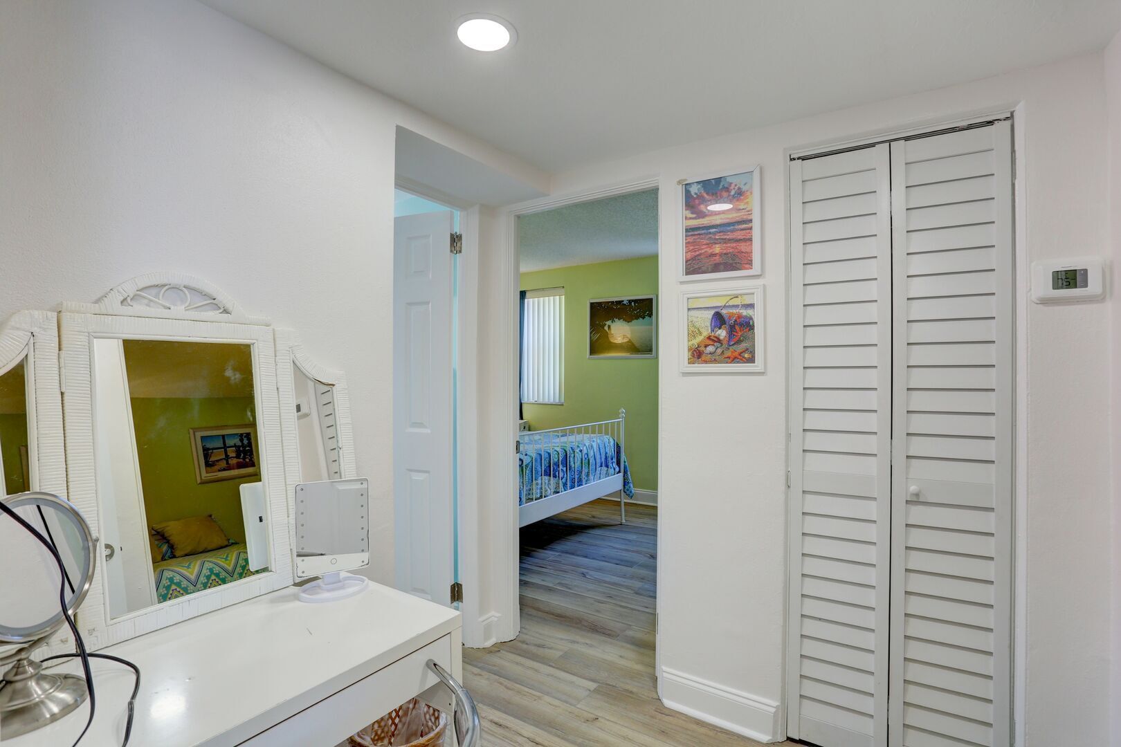 A bedroom with a bed, a dresser, a mirror, and a closet.
