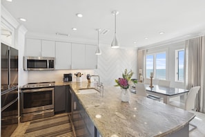 Enjoy cooking in this well-lit kitchen with a large window offering ocean views.