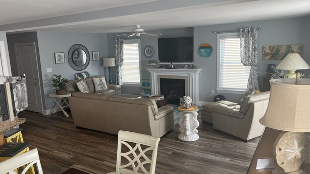 A living room with a fireplace, sofas, a television, and a dining area with chairs and a table.