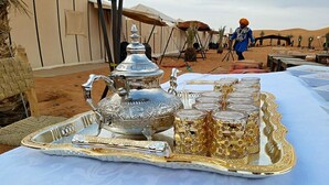 A table set with a silver and gold tray, a silver teapot, and several gold-rimmed glasses. - 3- Sweet Erg Chebbi Merzouga (Merzouga)