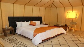 A tent-style bedroom with a bed, bedside tables, a chair, and a lamp. - 3- Sweet Erg Chebbi Merzouga (Merzouga)
