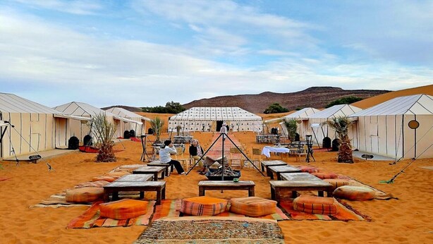 A desert camp with multiple tents, a central viewing platform, and a backdrop of hills. - 3- Sweet Erg Chebbi Merzouga (Merzouga)