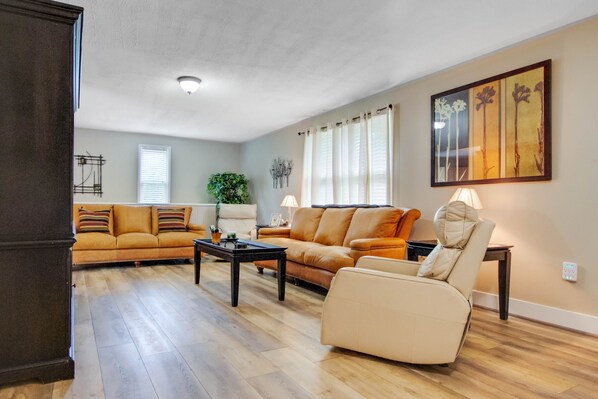 A living room with a sectional sofa, a beige armchair, and a coffee table.