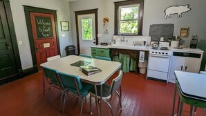 A cozy kitchen with a dining table, chairs, a stove, and a sink. - *CLOSED FOR 2026 SEASON* Schmidt Farm: an interactive farm experience (Preston)