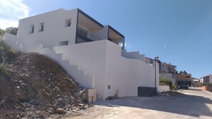 Edifici modern amb façana blanca i escala que condueix a un balcó.
