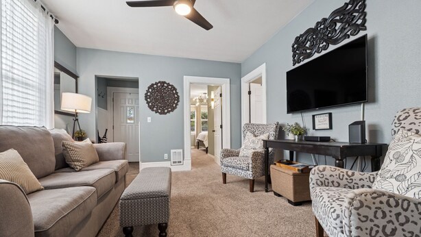 A living room with a sofa, ottoman, chairs, a TV, and a ceiling fan. - Just off 6th Ave!  Beautifully Renovated Home! Close to UPS. (Tacoma)