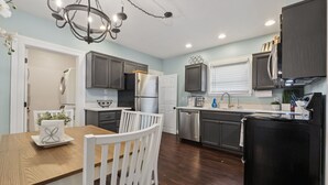 A kitchen with dark cabinets, a stainless steel refrigerator, a dishwasher, and a black microwave. - Just off 6th Ave!  Beautifully Renovated Home! Close to UPS. (Tacoma)