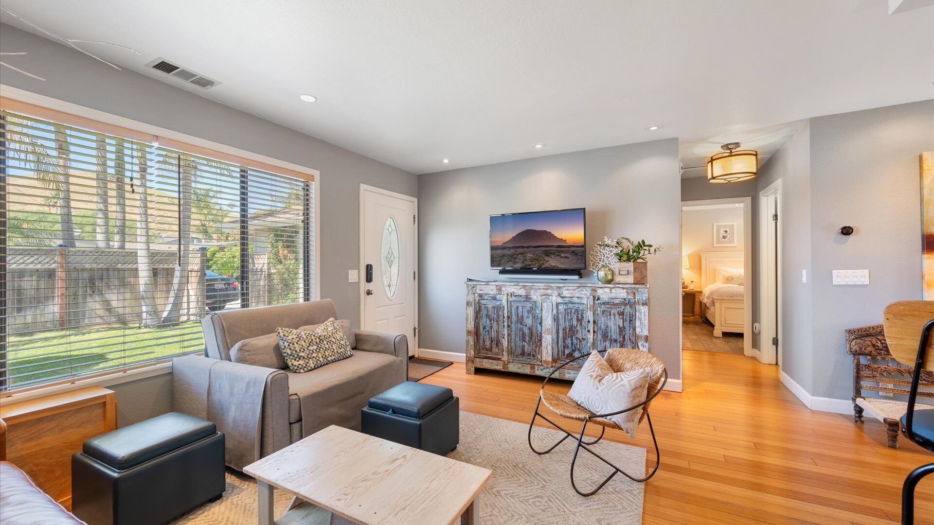The stylishly furnished living room features a large flat screen TV and the arm chair folds out to a twin sized bed