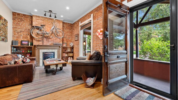 A cozy living room with a fireplace, leather sofas, and a bicycle mounted on the wall. - Exceptional and artful, modern Victorian. Very centrally located. Dog friendly! (Denver)