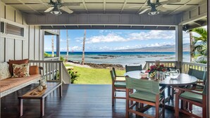 A covered outdoor seating area with a view of the ocean and hills. - Serene 3BR Puako Estate P10D – Beachfront Access & Tranquil Living (Kamuela)
