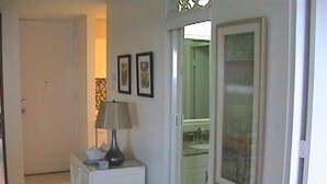 A hallway with a white cabinet, a lamp, and two framed pictures on the wall. - FLASH SALE:  Beautiful Beach Front Location (Carolina, Isla Verde)