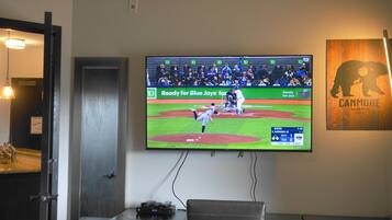 Un téléviseur fixé au mur diffuse un match de baseball.