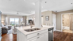 Una cocina moderna con una isla central, un comedor con vistas y un baño con ducha.