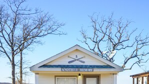 Un bâtiment d’un seul étage, doté d’une façade blanche, d’un petit porche et d’une enseigne sur laquelle on peut lire : « ENCORE UN SOUVENIR ».